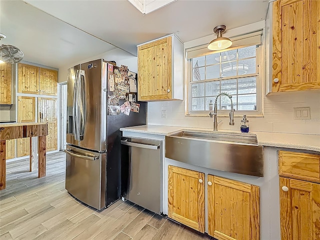 602 Mindy Dr, Largo, FL 33771 - kitchen with appliances with stainless steel finishes, a sink, decorative backsplash, light wood finished floors, and light countertops