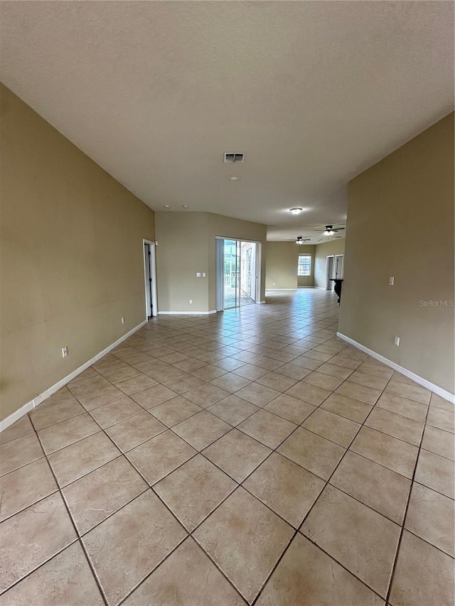 13632 Deventer Ct, Hudson, FL 34667 - unfurnished living room with light tile patterned floors, ceiling fan, and baseboards