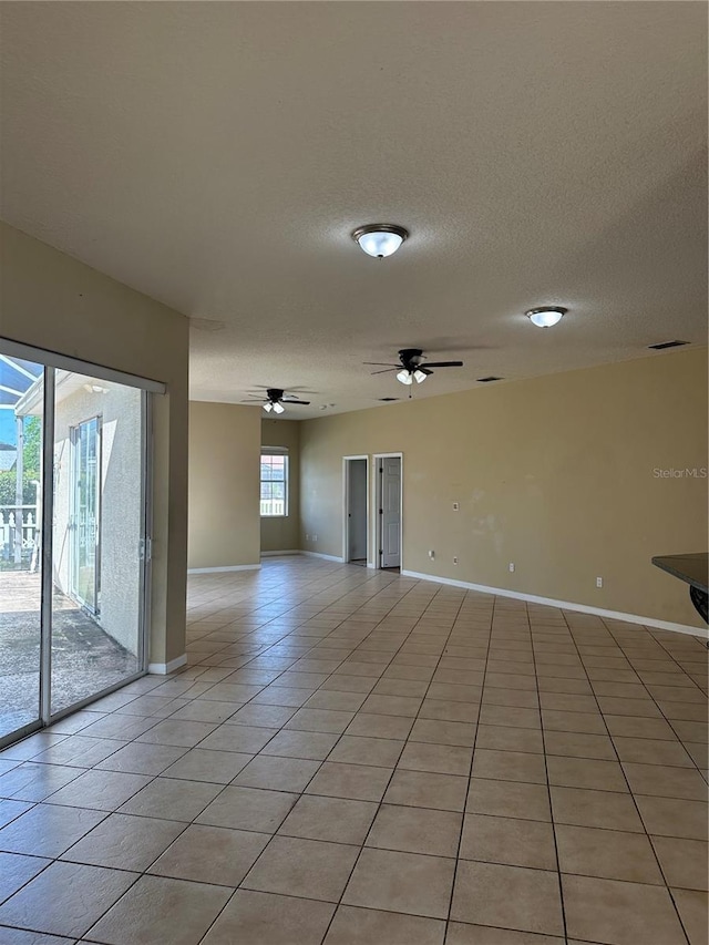 13632 Deventer Ct, Hudson, FL 34667 - empty room featuring light tile patterned floors, baseboards, a ceiling fan, and a textured ceiling