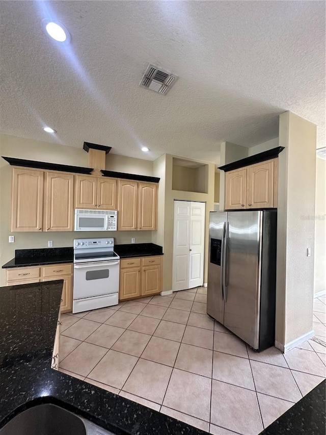 13632 Deventer Ct, Hudson, FL 34667 - kitchen featuring white appliances, light brown cabinets, a textured ceiling, light tile patterned floors, and recessed lighting