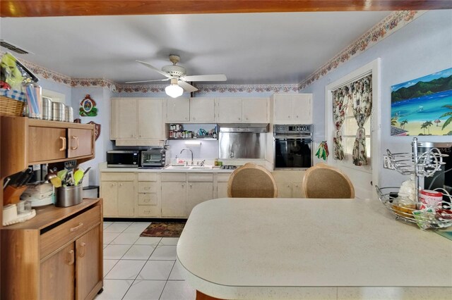 3626 S Hesperides St, Tampa, FL 33629 - kitchen featuring oven, under cabinet range hood, light countertops, a ceiling fan, and light tile patterned floors