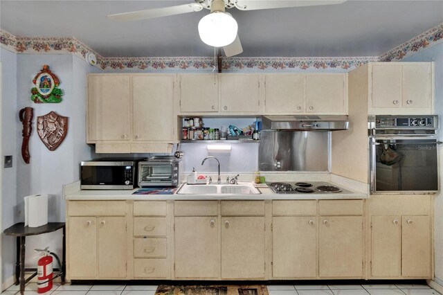 3626 S Hesperides St, Tampa, FL 33629 - kitchen with oven, a sink, stainless steel microwave, under cabinet range hood, and cream cabinetry