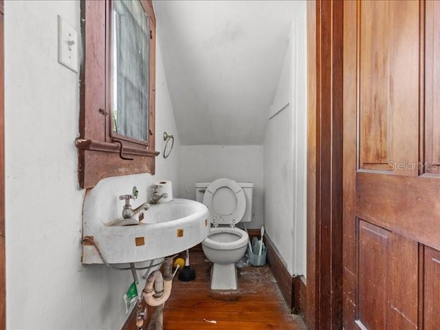 485 E Stanford St, Bartow, FL 33830 - bathroom with hardwood / wood-style flooring, vaulted ceiling, toilet, and a sink