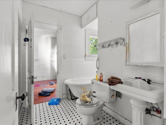 485 E Stanford St, Bartow, FL 33830 - full bathroom with a freestanding bath, a wainscoted wall, tile walls, tile patterned floors, and toilet