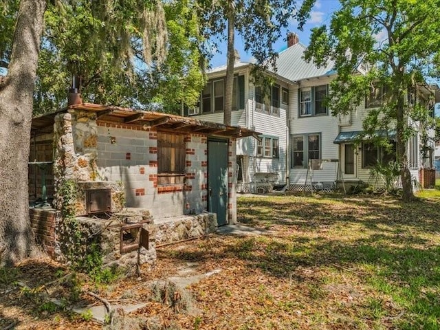 485 E Stanford St, Bartow, FL 33830 - back of property with a chimney, metal roof, and entry steps