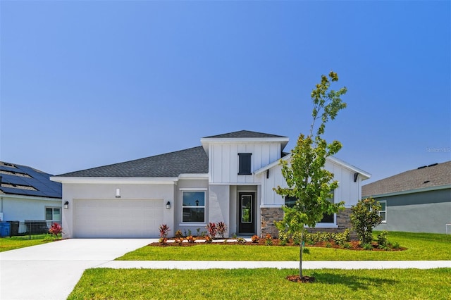 modern farmhouse featuring board and batten siding, a garage, a front lawn, concrete driveway, and roof with shingles