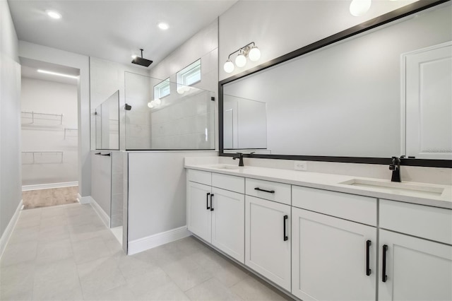 full bathroom with walk in shower, double vanity, baseboards, a spacious closet, and recessed lighting