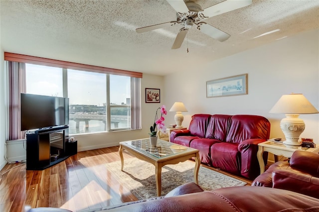 7465 Bay Island Dr S Unit 213, South Pasadena, FL 33707 - living room with a textured ceiling, wood finished floors, a ceiling fan, and baseboards