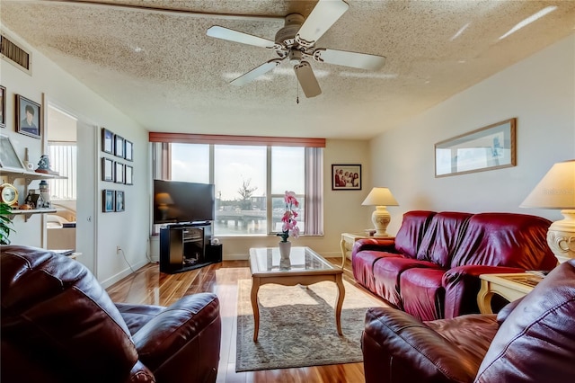 7465 Bay Island Dr S Unit 213, South Pasadena, FL 33707 - living area with healthy amount of natural light, wood finished floors, a textured ceiling, and ceiling fan