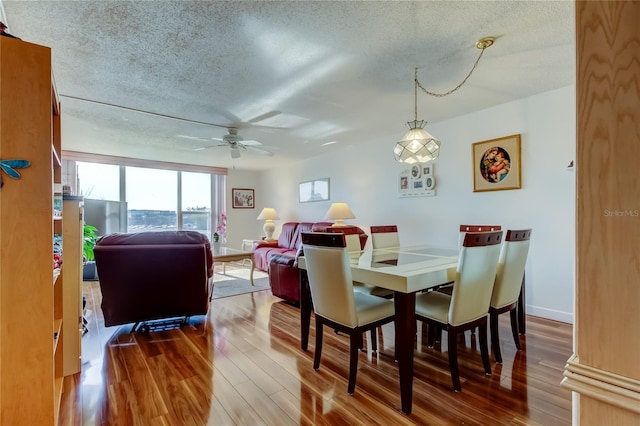 7465 Bay Island Dr S Unit 213, South Pasadena, FL 33707 - dining room featuring a textured ceiling, a ceiling fan, and wood finished floors