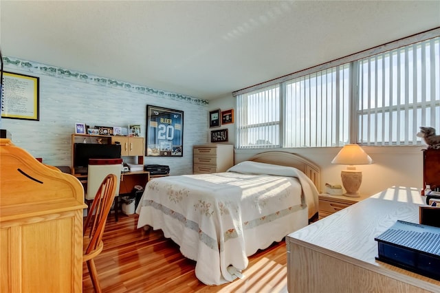 7465 Bay Island Dr S Unit 213, South Pasadena, FL 33707 - bedroom featuring wallpapered walls and light wood-type flooring
