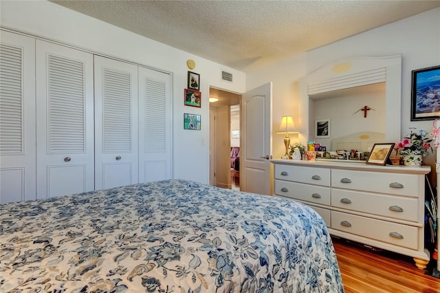 7465 Bay Island Dr S Unit 213, South Pasadena, FL 33707 - bedroom featuring wood finished floors, a closet, and a textured ceiling
