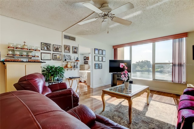 7465 Bay Island Dr S Unit 213, South Pasadena, FL 33707 - living area featuring a textured ceiling, light wood-style floors, and ceiling fan