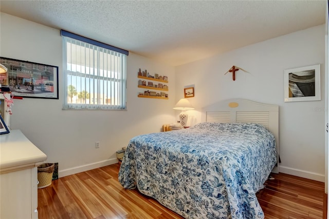 7465 Bay Island Dr S Unit 213, South Pasadena, FL 33707 - bedroom with wood finished floors, baseboards, and a textured ceiling