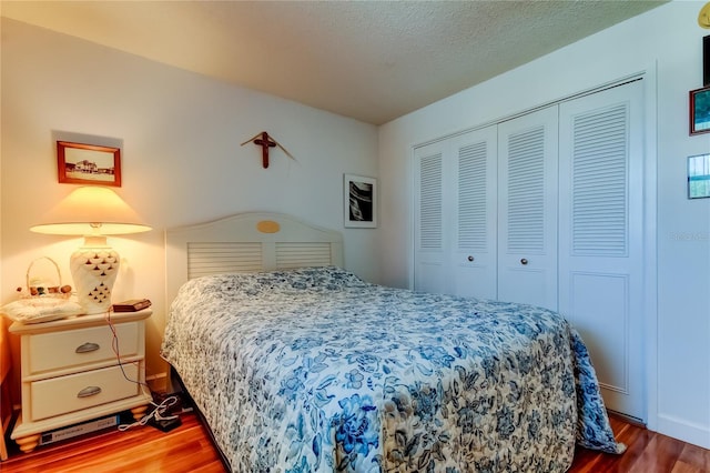 7465 Bay Island Dr S Unit 213, South Pasadena, FL 33707 - bedroom featuring wood finished floors, a closet, and a textured ceiling