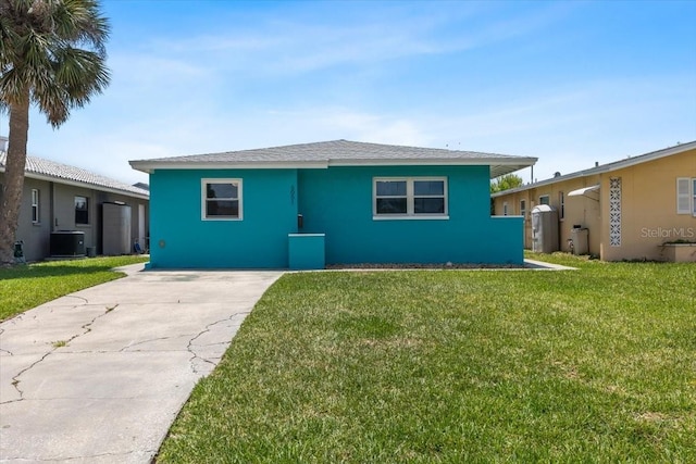 5051 Bonito Dr, New Port Richey, FL 34652 - view of front of property featuring central air condition unit, a front lawn, stucco siding, and driveway