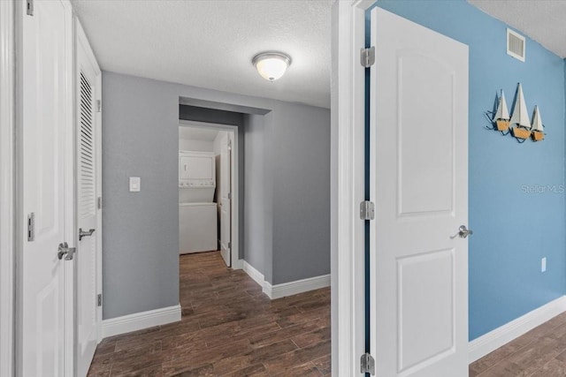 5051 Bonito Dr, New Port Richey, FL 34652 - corridor featuring estacked washer and dryer, a textured ceiling, wood finished floors, and baseboards