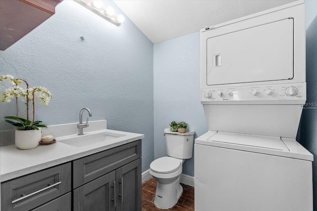5051 Bonito Dr, New Port Richey, FL 34652 - bathroom with estacked washer and dryer, toilet, wood finished floors, vanity, and a textured wall