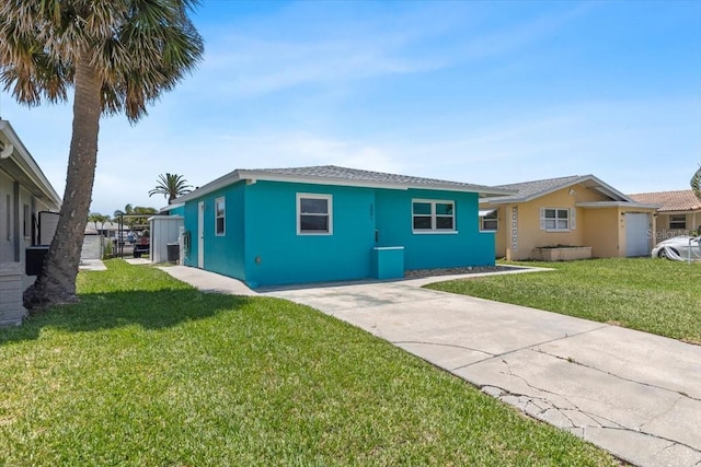 5051 Bonito Dr, New Port Richey, FL 34652 - view of front facade with a front yard, stucco siding, and driveway