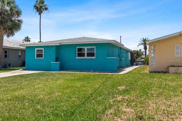 5051 Bonito Dr, New Port Richey, FL 34652 - back of house with a yard and stucco siding