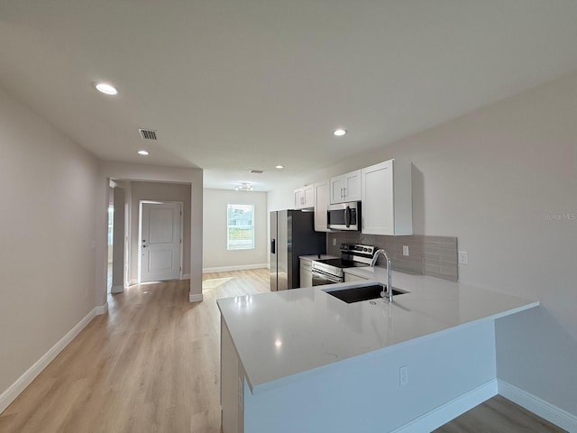 12231 Kirk Ave, Port Charlotte, FL 33981 - kitchen with stainless steel appliances, a sink, backsplash, light wood-style floors, and recessed lighting