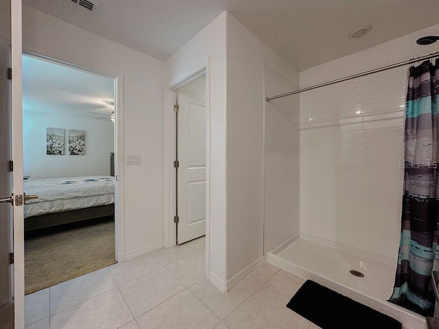 6444 Bar S Bar Trl, Zephyrhills, FL 33541 - ensuite bathroom with tiled shower, tile patterned flooring, baseboards, and a ceiling fan