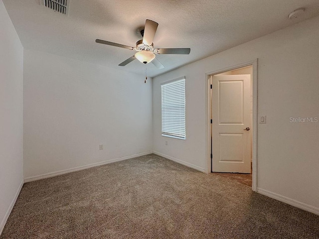 6444 Bar S Bar Trl, Zephyrhills, FL 33541 - empty room featuring carpet flooring, ceiling fan, baseboards, a smoke detector, and a textured ceiling
