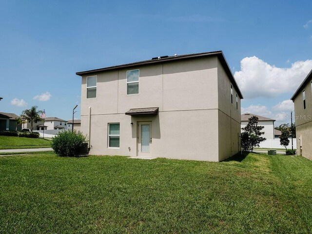 6444 Bar S Bar Trl, Zephyrhills, FL 33541 - back of house featuring a yard and stucco siding