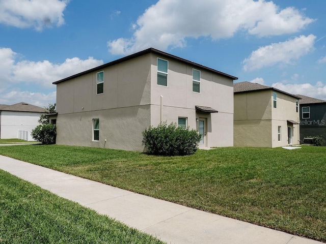 6444 Bar S Bar Trl, Zephyrhills, FL 33541 - view of property exterior with stucco siding and a lawn