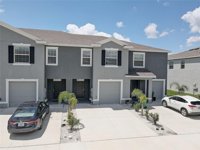 33062 Frosted Clover Way, Wesley Chapel, FL 33545 - townhome / multi-family property featuring stucco siding, driveway, a garage, and a shingled roof