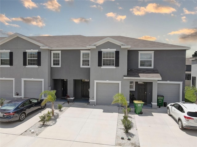 33062 Frosted Clover Way, Wesley Chapel, FL 33545 - multi unit property featuring stucco siding, a garage, driveway, and a shingled roof