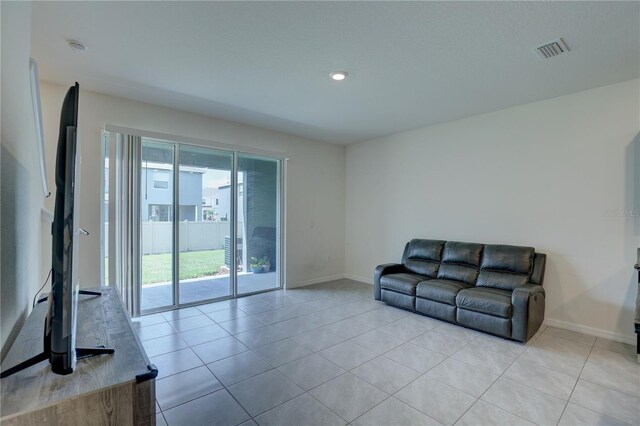33062 Frosted Clover Way, Wesley Chapel, FL 33545 - unfurnished living room with baseboards, light tile patterned floors, and recessed lighting