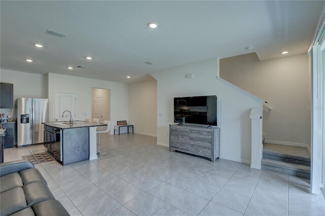 33062 Frosted Clover Way, Wesley Chapel, FL 33545 - kitchen featuring stainless steel fridge with ice dispenser, open floor plan, a sink, recessed lighting, and a kitchen breakfast bar