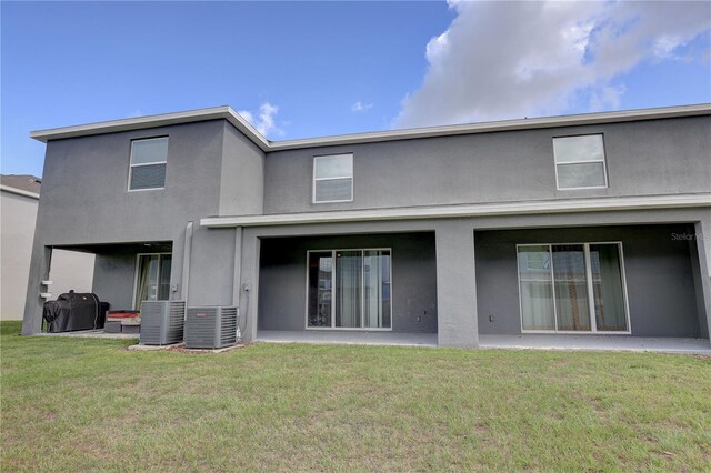 33062 Frosted Clover Way, Wesley Chapel, FL 33545 - rear view of house with stucco siding, central AC, and a yard