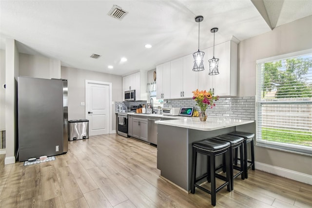 509 Stone Dr, Brandon, FL 33510 - kitchen featuring appliances with stainless steel finishes, light countertops, a peninsula, tasteful backsplash, and plenty of natural light