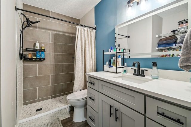 509 Stone Dr, Brandon, FL 33510 - bathroom with vanity, toilet, a tile shower, wood finished floors, and a textured ceiling