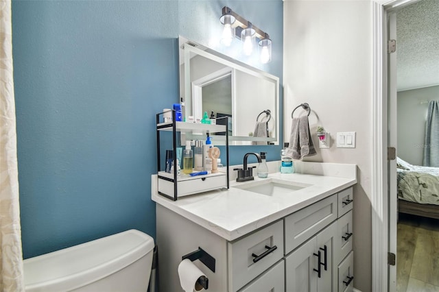 509 Stone Dr, Brandon, FL 33510 - ensuite bathroom featuring toilet, wood finished floors, vanity, and a textured ceiling
