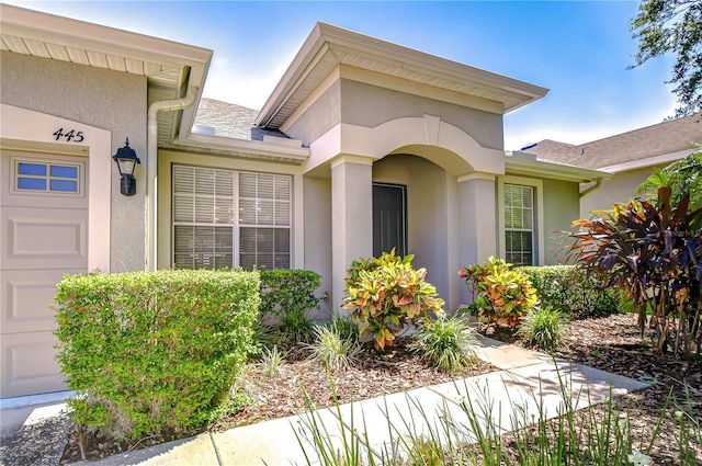 445 Arch Ridge Loop, Seffner, FL 33584 - view of exterior entry featuring stucco siding and an attached garage