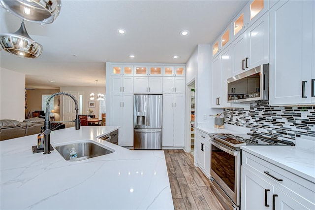 445 Arch Ridge Loop, Seffner, FL 33584 - kitchen with appliances with stainless steel finishes, a sink, light wood-type flooring, open floor plan, and recessed lighting