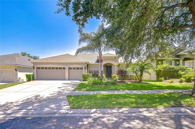 445 Arch Ridge Loop, Seffner, FL 33584 - ranch-style home with stucco siding, a garage, driveway, and a front lawn