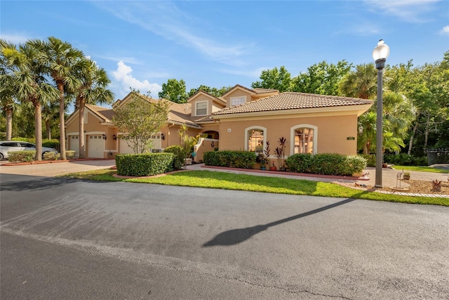 7246 Gaberia Rd, New Port Richey, FL 34655 - mediterranean / spanish house with a tiled roof, concrete driveway, stucco siding, and a garage