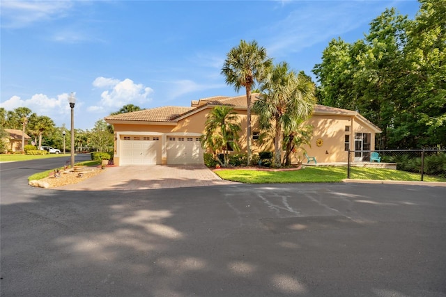 7246 Gaberia Rd, New Port Richey, FL 34655 - mediterranean / spanish home featuring driveway, a garage, stucco siding, and a tiled roof