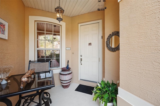 7246 Gaberia Rd, New Port Richey, FL 34655 - doorway to property featuring covered porch and stucco siding