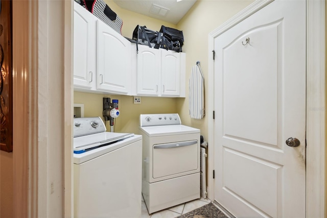 7246 Gaberia Rd, New Port Richey, FL 34655 - laundry room with washing machine and dryer, cabinet space, and light tile patterned floors