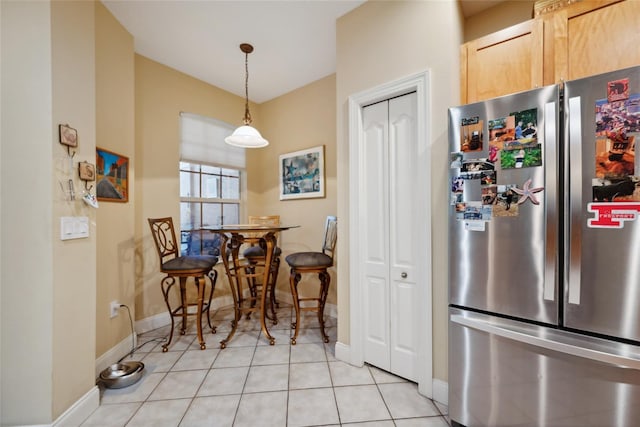 7246 Gaberia Rd, New Port Richey, FL 34655 - kitchen with freestanding refrigerator, light tile patterned floors, baseboards, light brown cabinetry, and pendant lighting