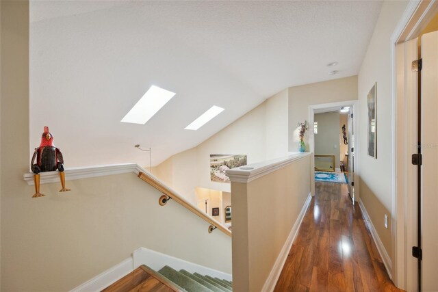 7246 Gaberia Rd, New Port Richey, FL 34655 - hall featuring a skylight, wood finished floors, an upstairs landing, vaulted ceiling, and baseboards