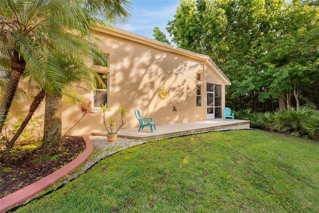 7246 Gaberia Rd, New Port Richey, FL 34655 - rear view of house with stucco siding, a yard, and a patio area