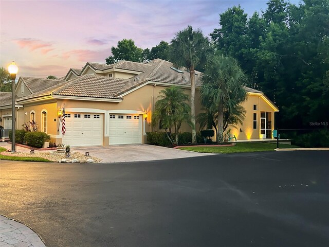 7246 Gaberia Rd, New Port Richey, FL 34655 - view of front of home featuring stucco siding, an attached garage, driveway, and a tile roof