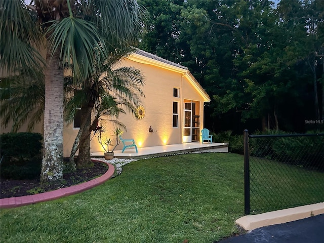 7246 Gaberia Rd, New Port Richey, FL 34655 - view of property exterior featuring stucco siding, a yard, and a patio area