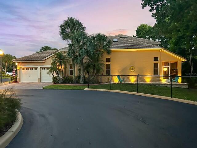 7246 Gaberia Rd, New Port Richey, FL 34655 - view of front of property with asphalt driveway, a garage, stucco siding, and a tiled roof